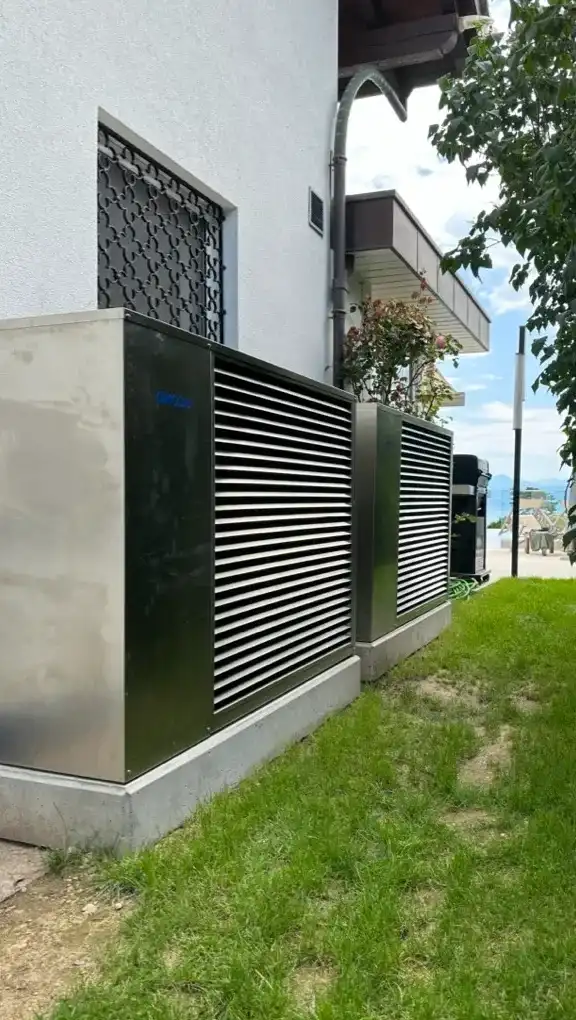 Installation de pompes à chaleur commerciales pour un chauffage efficace en Suisse romande Deux pompes à chaleur commerciales installées à l’extérieur d’un bâtiment en Suisse romande pour un chauffage écoénergétique